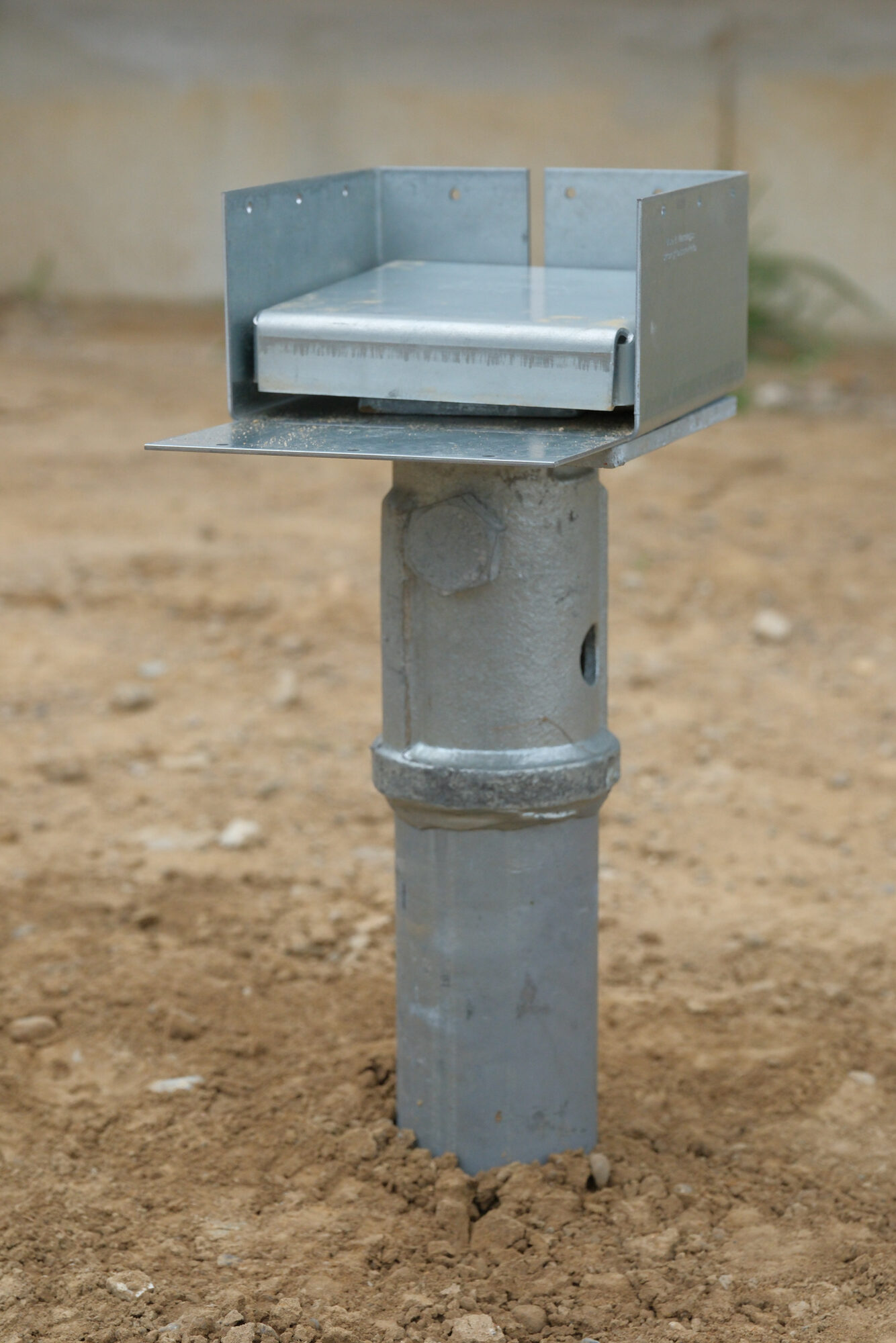 Galvanized PierTech bracket bolted to the top of an installed helical pier, ready for a beam or post