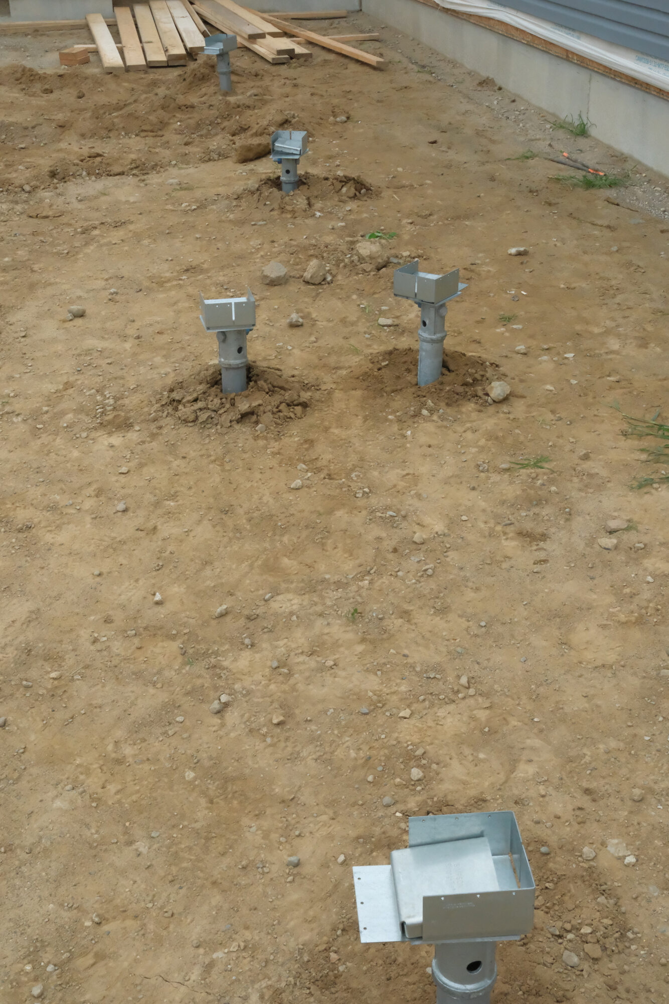 Row of installed helical piers with PierTech brackets, ready for framing